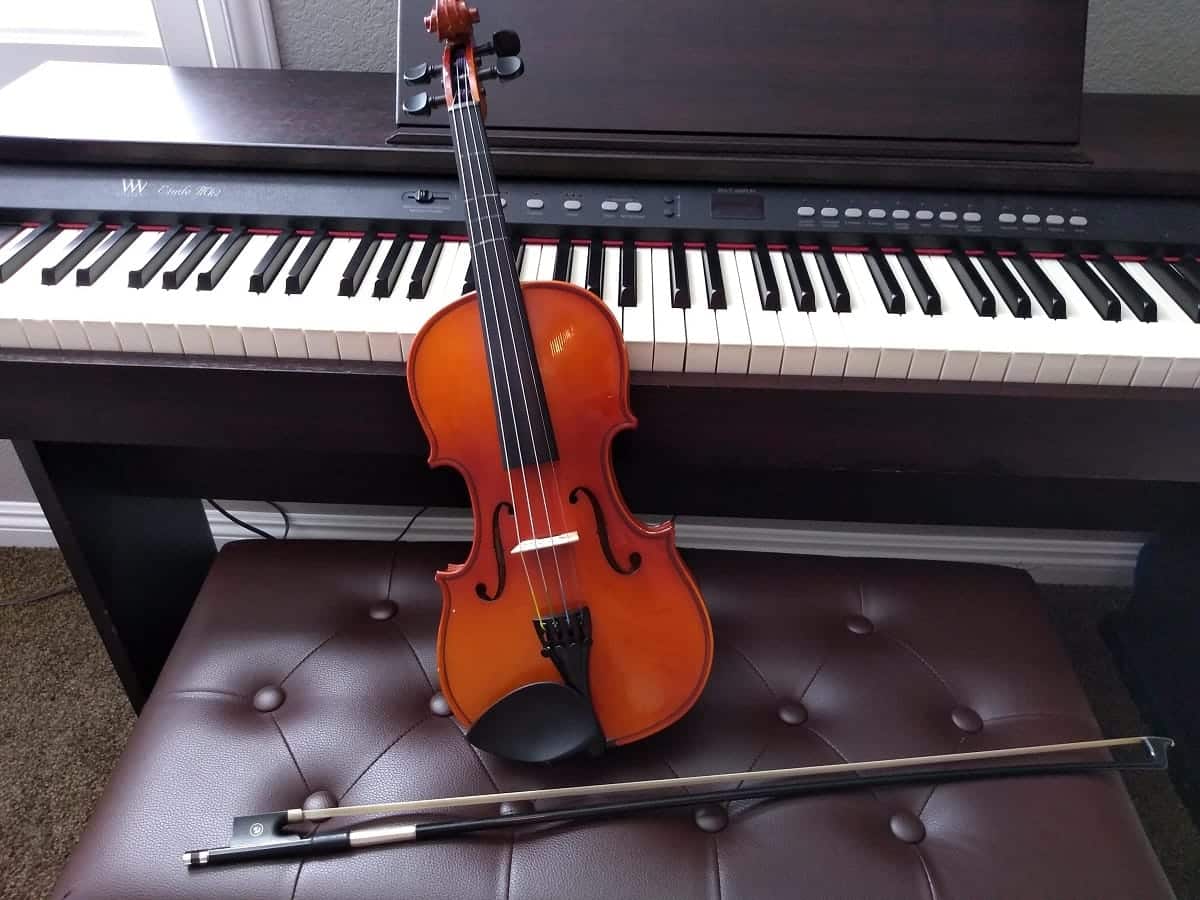 violin sitting against a piano