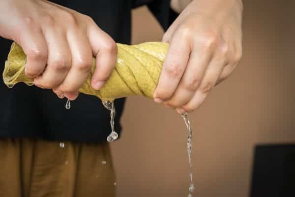 guy ringing out a wet cloth