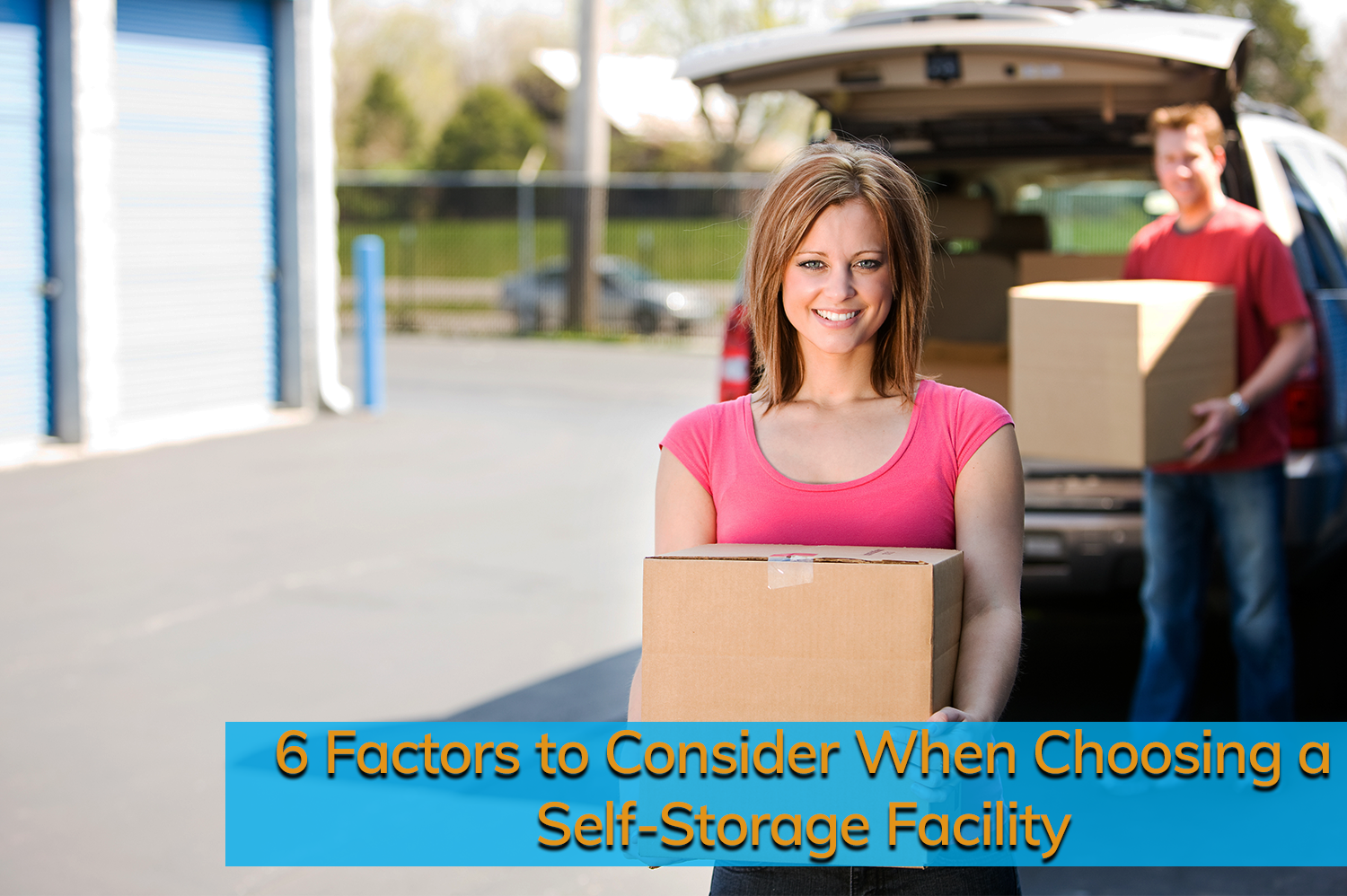 White woman with short blonde hair and pink t-shirt unloads boxes from her car at a self-storage facility.